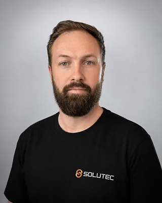 Mann med brunt hår og svart t-skjorte